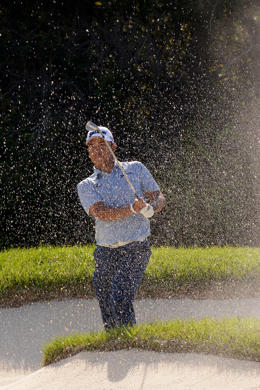 Hideki Matsuyama kicks up sand with his bunker shot on the No. 12 hole at The Concession Golf Club. Matsuyama would birdie the hole. He shot four under par for the round and is 10 under par overall.