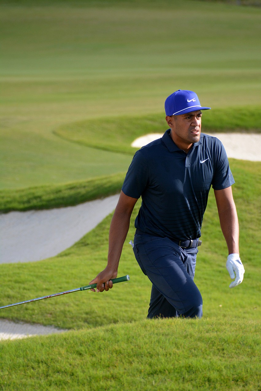 Tony Finau walks to pick up his ball after his chip shot on the No. 12 green at The Concession Golf Club. Finau would par the hole. He shot even par for the round and is nine under par overall.