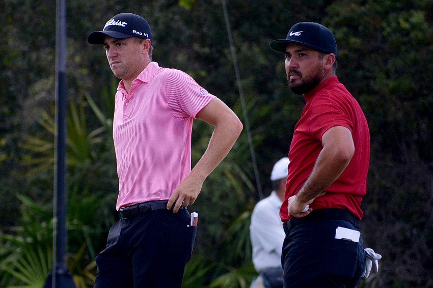 Justin Thomas and Jason Day wait for their turns to putt on the No. 12 hole at The Concession Golf Club.