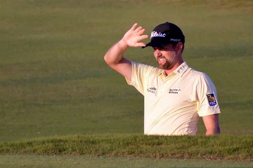 Webb Simpson fights the sun while watching his approach on the No. 18 hole at The Concession Golf Club. Simpson would par the hole.