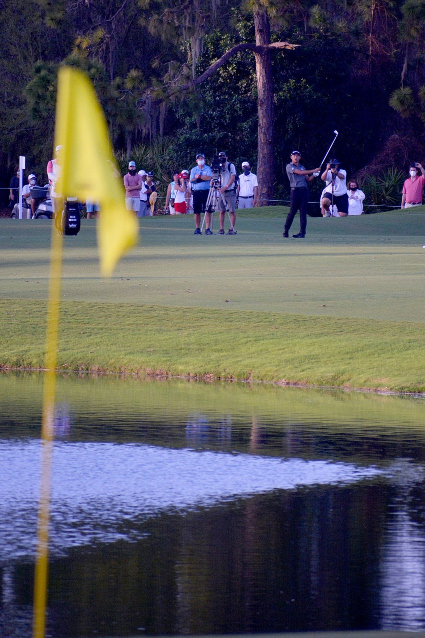 Collin Morikawa shoots his second shot from across the lake on the No. 18 hole at The Concession Golf Club.