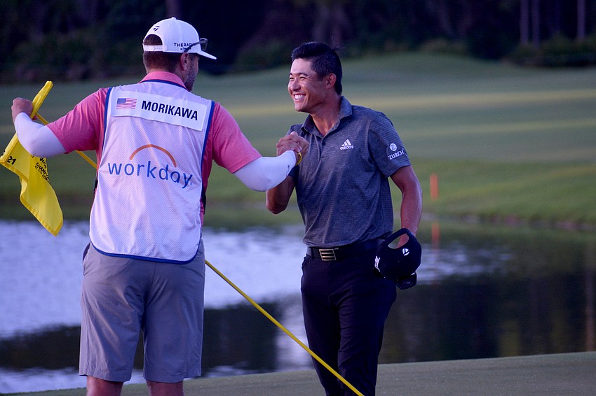 Collin Morikawa celebrates with his caddie after winning the World Golf Championships-Workday Championship at The Concession.