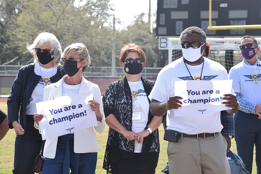 School District of Manatee County employees hold up signs to show support for the more than 6,000 district employees during the kickoff of Champions of Education.