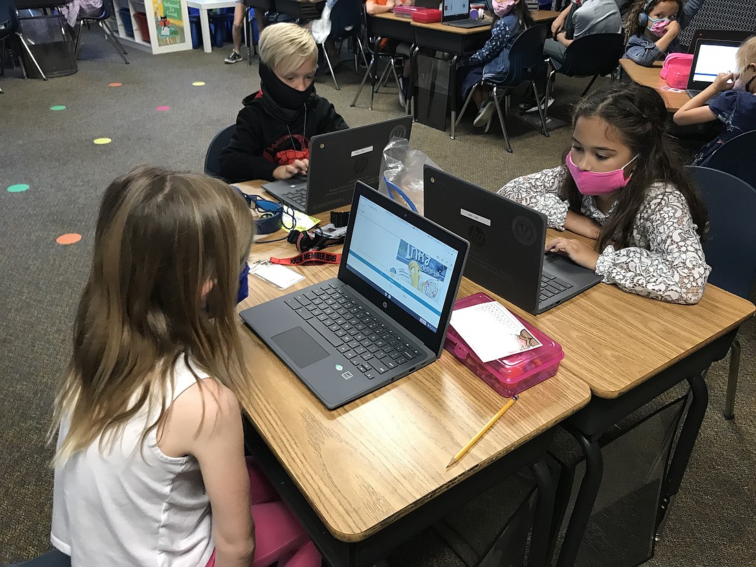 Layden Kraut, Sophia Marzonie and Isabella Moncion, first graders at B.D. Gullett Elementary School are all used to using laptops. Courtesy photo.