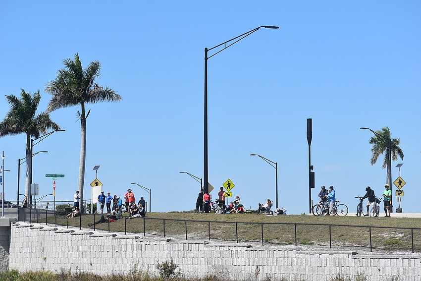 Passersby and Nathan Benderson Park visitors gather outside the park fence to watch Nik Wallenda's Daredevil Rally.