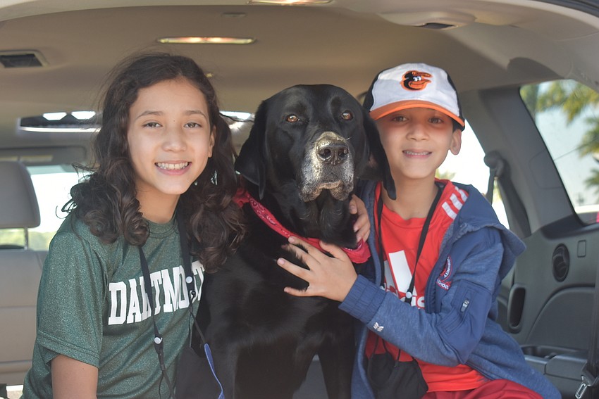 Sarasota residents Beatrice DeGuzman, 11, and Holden DeGuzman, 9, hold their 7-year-old Labrador retriever, Marker. Beatrice enjoyed Galaxy Girl's performance most, while Holden liked the BMX riders.