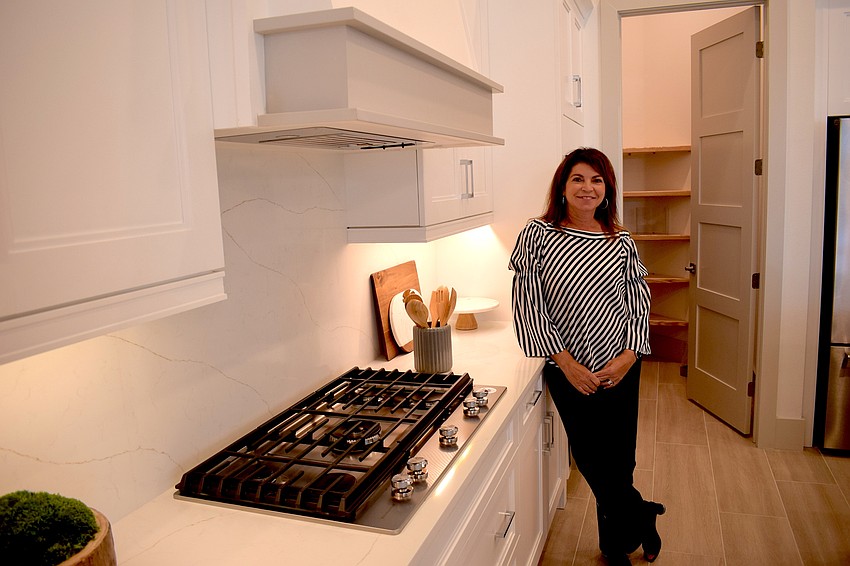 Stock Area Sales Manager Debbie Urban stands in the kitchen of the Clairborne II model, which is 4,396 square feet under air and 6,961 total square foot with the lanai.