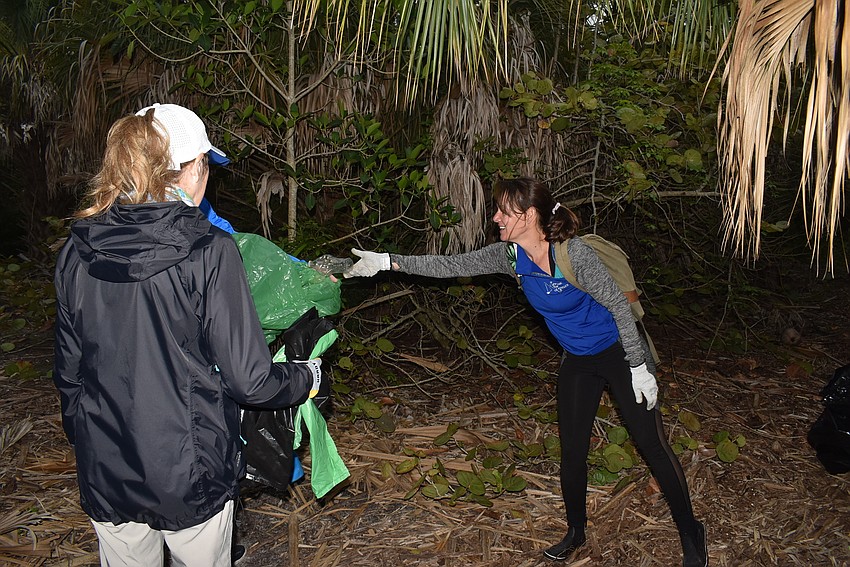 Lyn Haycock holds a bag open for Ali Claypoole.