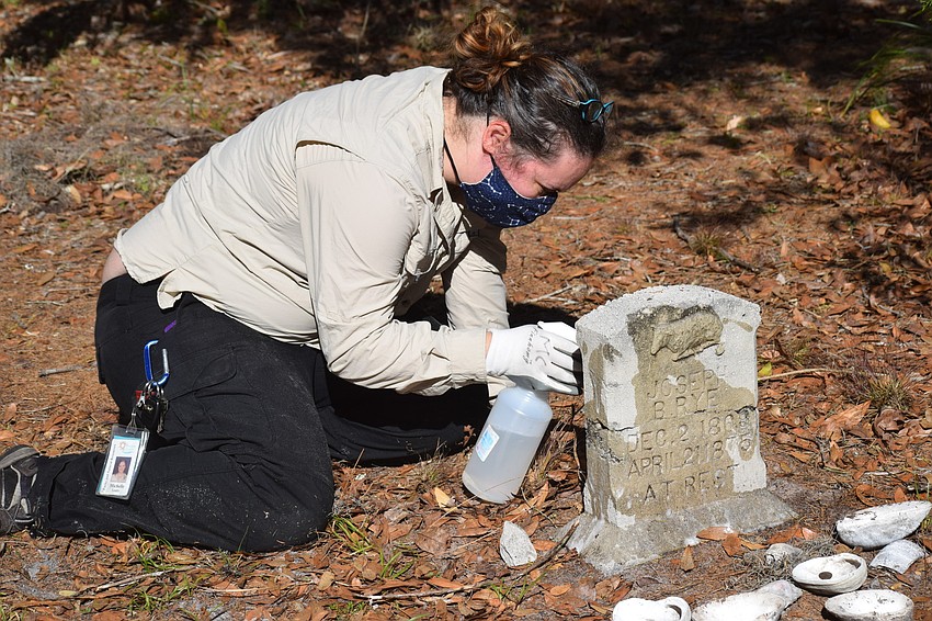 Michelle Leahy, a Manatee County volunteer specialist for Parks and Natural Resources, works on a headstone during the Rye Cemetery Preservation and Beautification project.