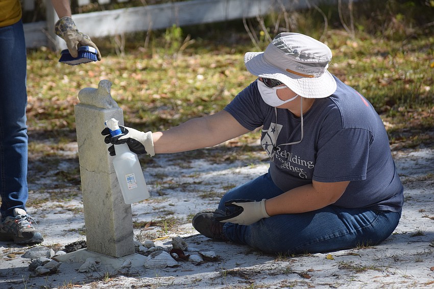 East County's Laurel Audet removes lichens and fungi from the stone.
