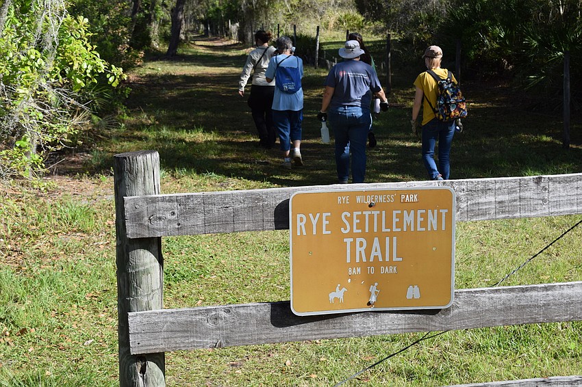 Manatee County staff members and volunteers begin the walk back to the Rye historic cemetery.