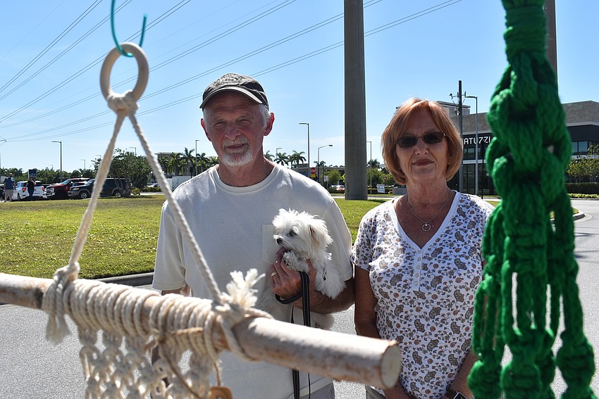 Country Club East residents Dan and Vicki Lisenby look at the macrame knot art at Art by Victoria with their 4-month-old Maltese, Liyla.