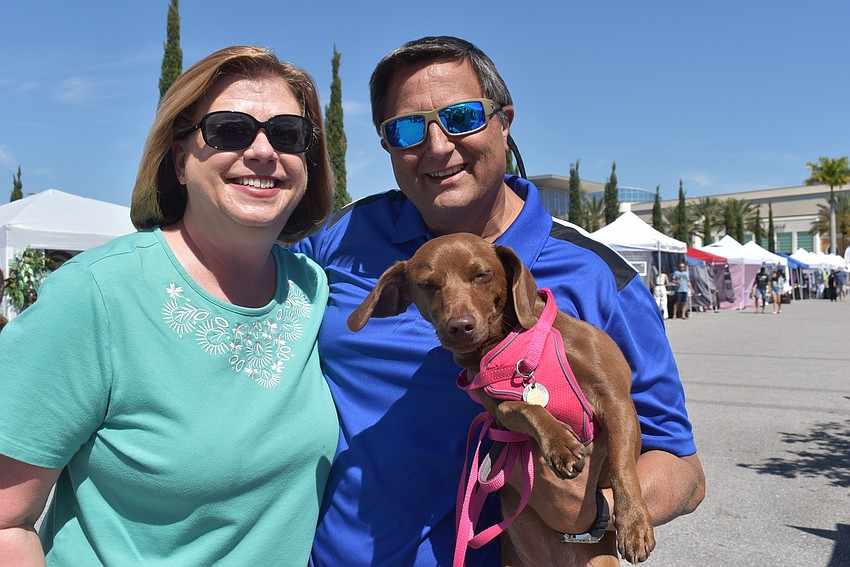 Reserve at Crossing Creek residents Lorraine and Ken Salazar hold 1-year-old rescue dog Molly. They love craft fairs and especially enjoyed the decorative cyprus driftwood on display by Sam VanDyk.