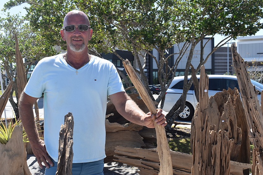 West Bradenton's Sam VanDyk stands with his decorative cyprus driftwood. He started using driftwood to create homemade crafts two years ago.