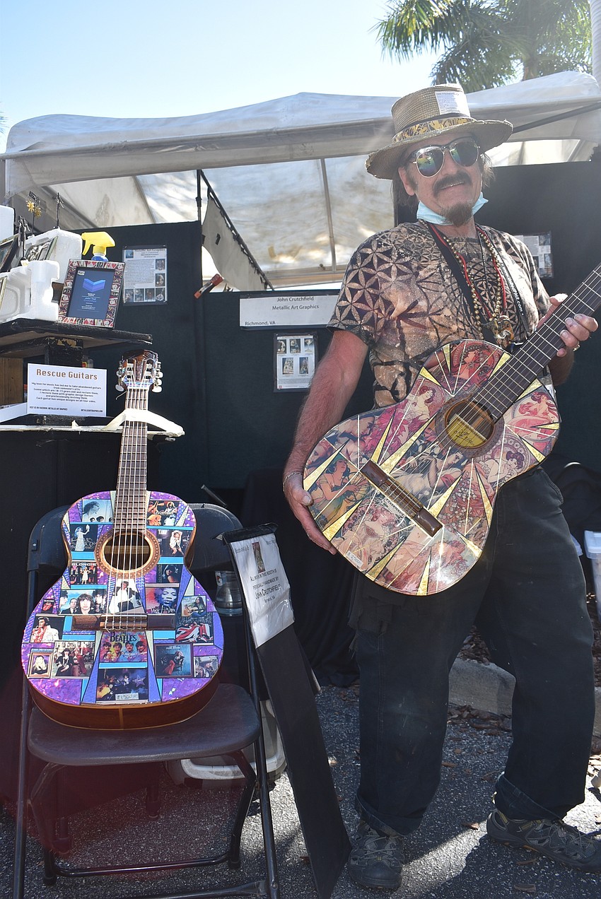 Richmond, Virginia-based artist John T. Crutchfield stands with his Rescue Guitars. The guitars are 10 to 15 years old and were abandoned. Crutchfield restored them with graphic art and replaced the strings so they can be played.
