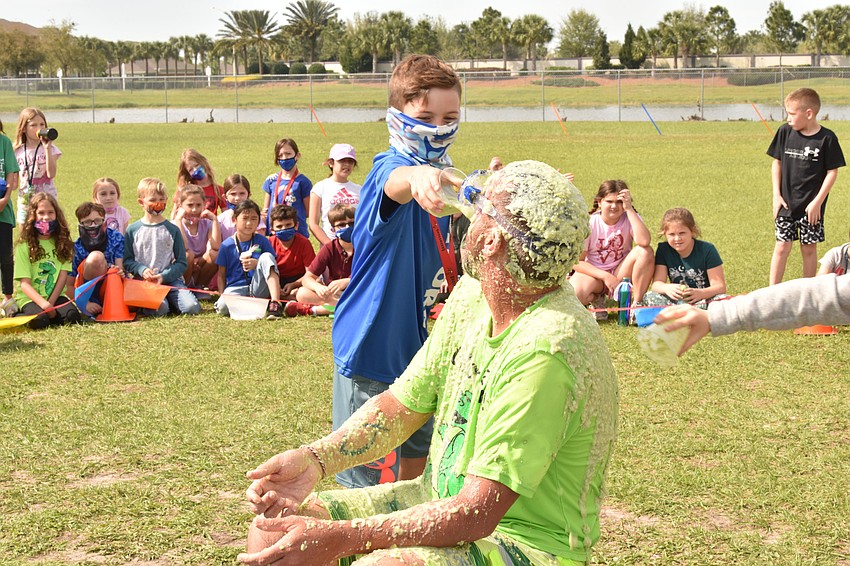 Third grader Kaden Pomeroy throws a cup of slime on his principal, Todd Richardson.