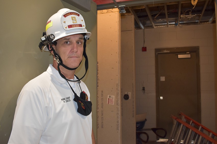 Fire Chief Paul Dezzi demonstrates how the new Fire Station 92’s red, yellow and green decontamination system will work. Firefighters will take two showers before they can return inside of the building.