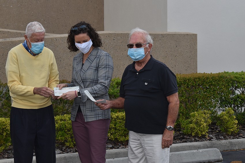 Jerry Fox presents a check to Harvest House CEO Erin Minor.