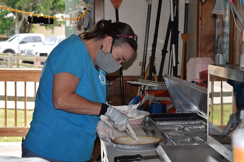 Rita Lewis cuts a piece of sour orange pie. People who order a sour orange pie will be able to keep the tin it comes in.