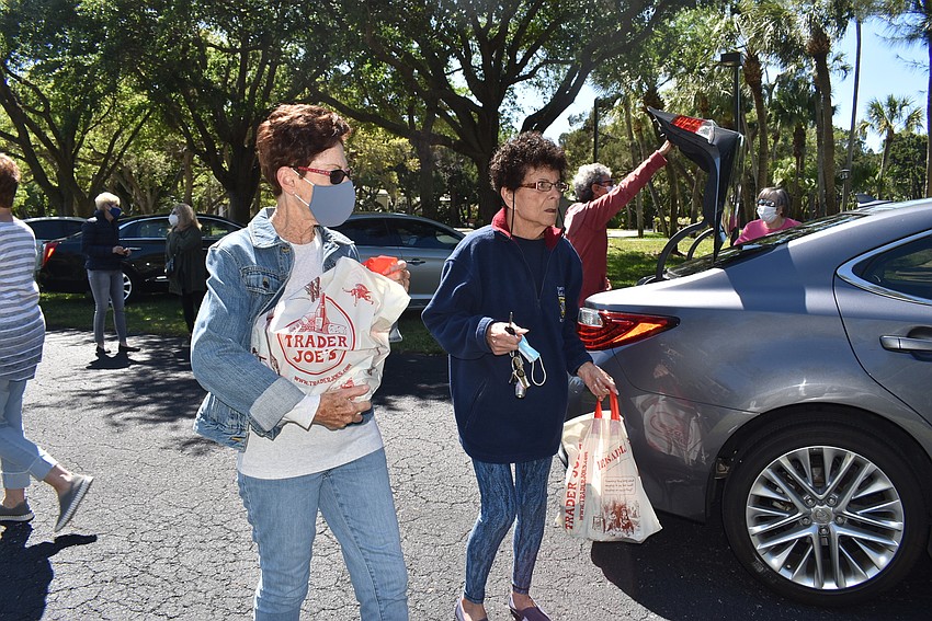 Debbie Nyman and Barbara Pressman unload a car.