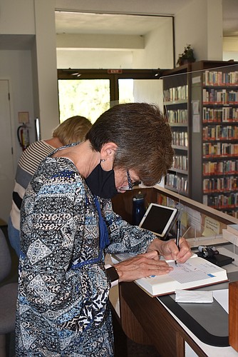 Susan Jones stamps a newly checked out book.