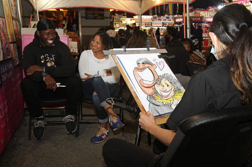 Unique Johnson and Alane Murrell have their caricatures drawn.