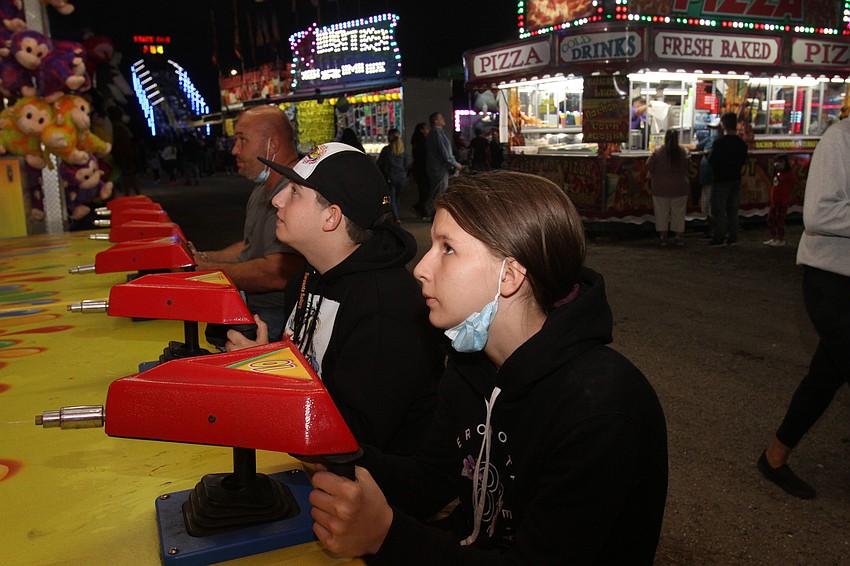 Savannah Standridge, Ricky Barter and Chris Quandt play carnival games.