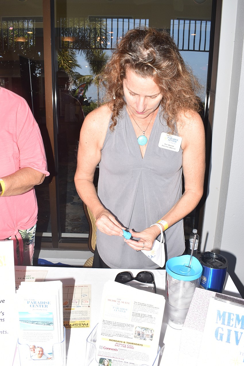 Suzy Brenner stamps an attendee's raffle card.