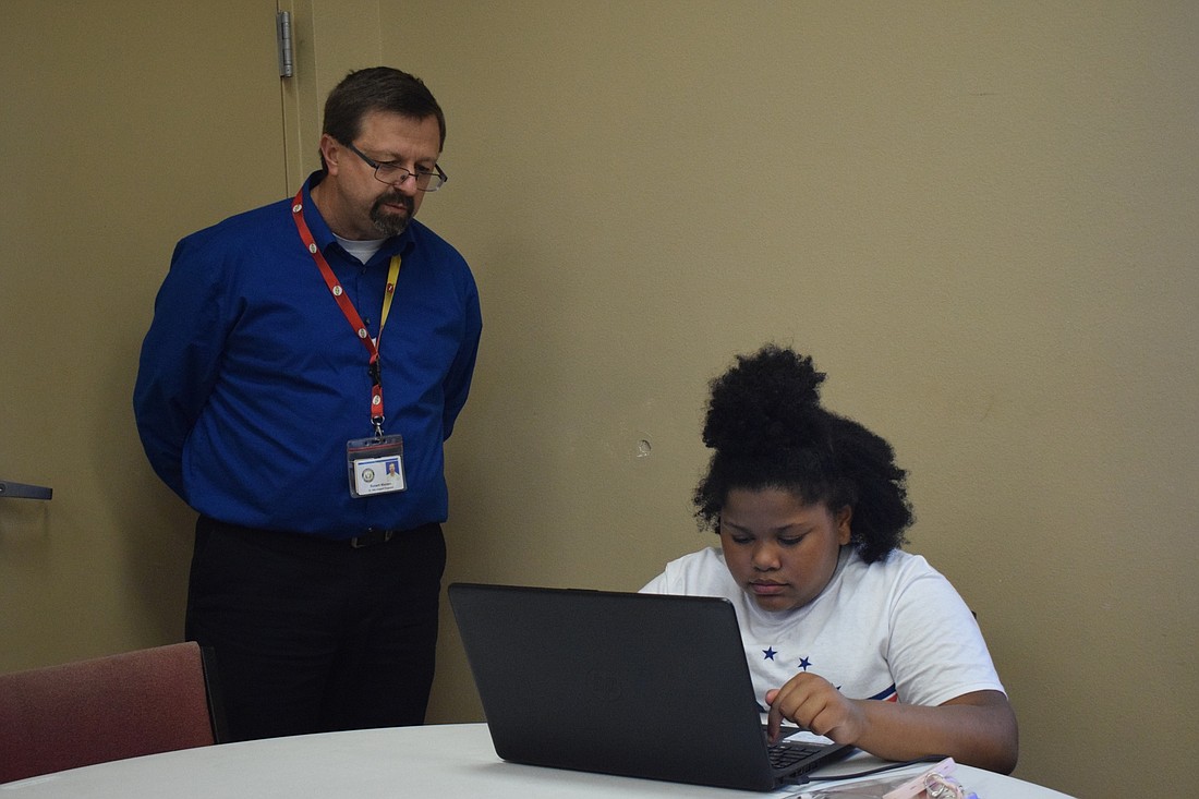 Rob Walden, a data center engineer for the School District of Manatee County, helps Bryanna Bacon, a third grader at Ballard Elementary, sign onto Schoology at Ward Temple AME Church in April 2020. File photo.