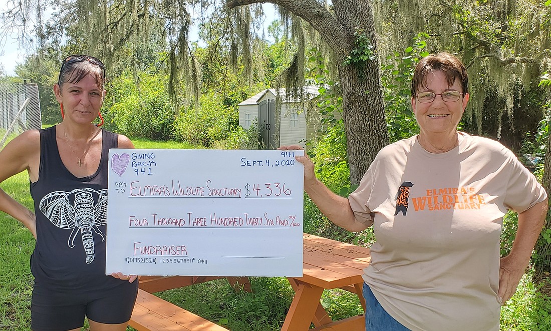 Giving Back 941, Inc. founder Holley Dekmar presents a check for $4,336 to Robin Greenwood, the board president and CEO of Elmira&#39;s Wildlife Sanctuary in Wimauma. (Courtesy of Holley Dekmar)