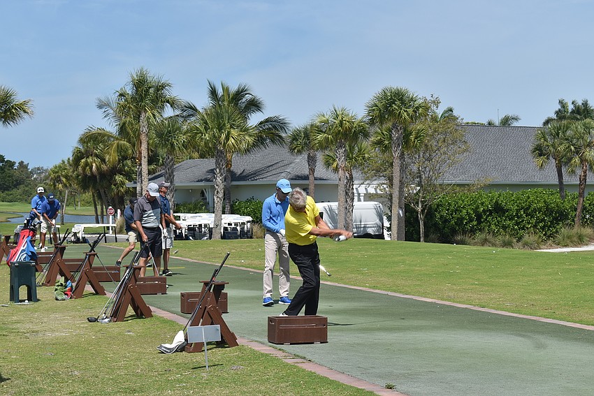Men lined up on the driving range to prepare for their round.