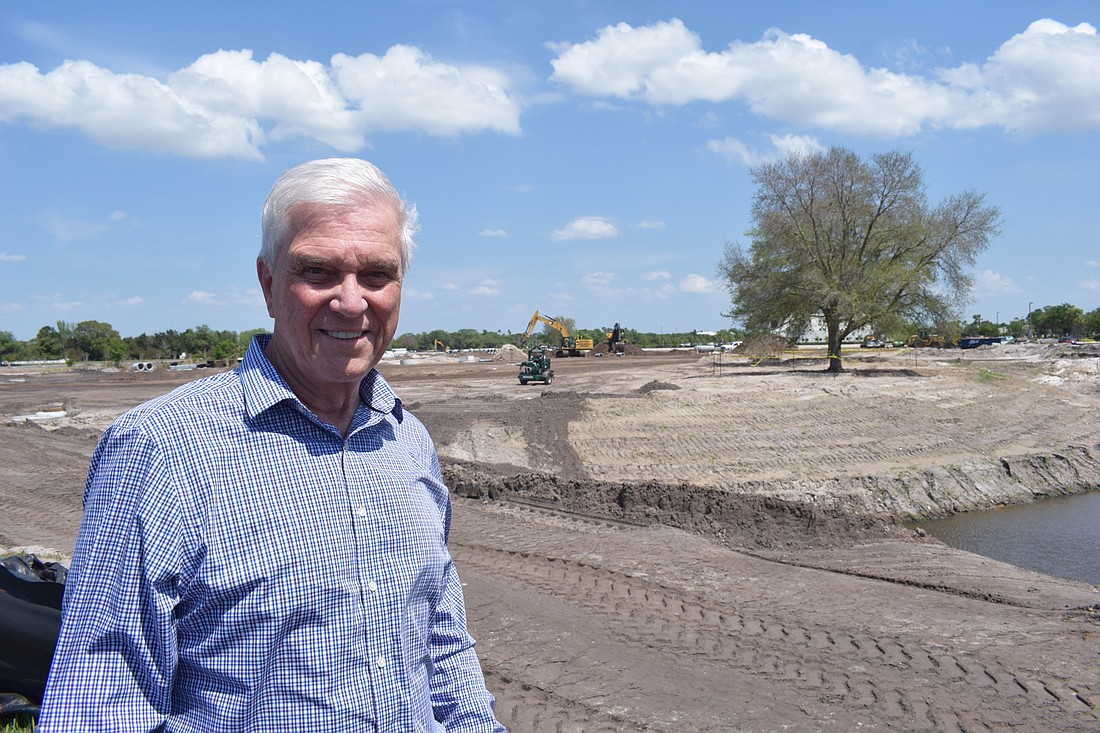 Brett Hutchens, the principal for CASTO, stands at the Center Point project in Lakewood Ranch. In the background is one of the adult oak trees that was saved and moved on the property.