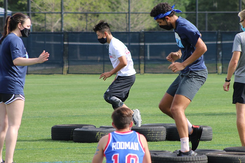 Seniors Arthur Wang and Grant Massey run through tires as part of an obstacle course for seniors. Courtesy photo.