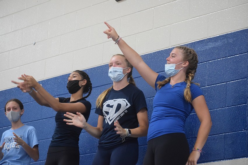 Eighth graders Ava Vatter, Ailese Bermudez, Charley Hunn and Alexa Gettel dance to the music while cheering for their classmates. Photo by Liz Ramos.