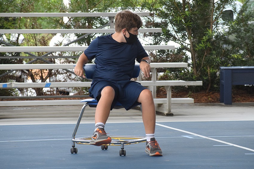 Jeffrey Horr, a sixth grader, goes as fast as he can in a chair relay race. 