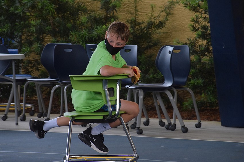 Hayne Falck, a sixth grader, looks to see if he's passing his competitors in a chair relay race. Photo by Liz Ramos.