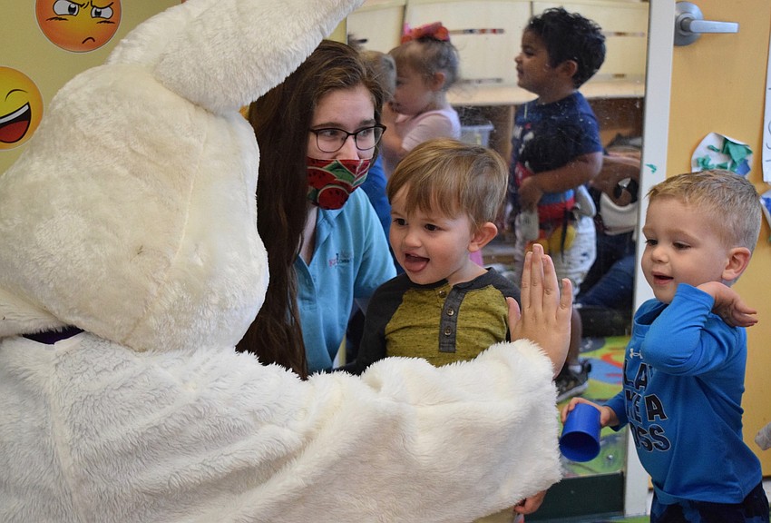 Carson Walsworth and Nicholas Lyons give a high-five to the Easter bunny.