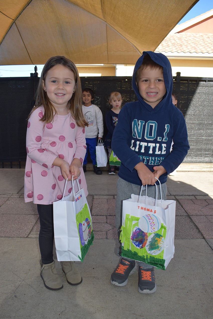Aerith Curtis and Thomas Parziale, who are 4 years old, show off the bags they decorated themselves.