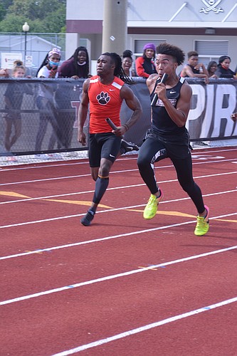 Senior Miles Stephens (right) completes the final stretch of the boys 4x100 race. The Pirates would win the race and set a new school record (43.23).