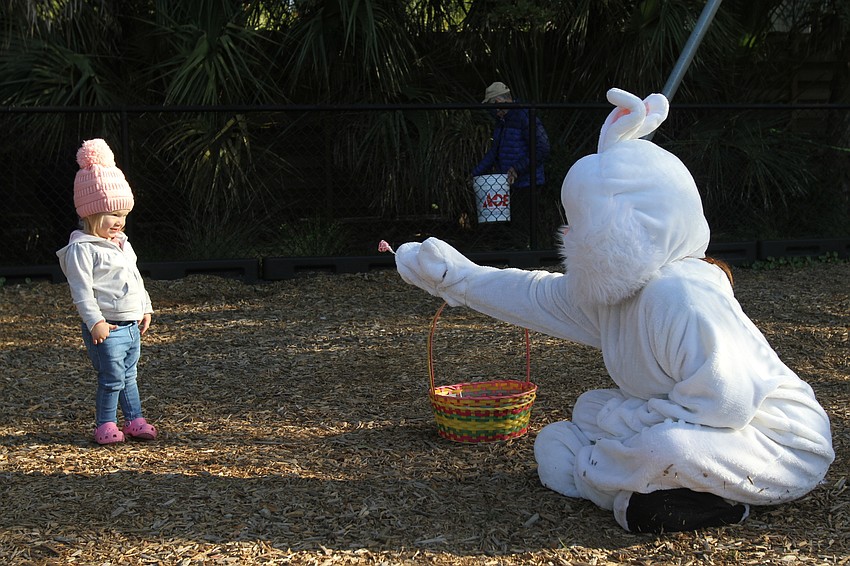 Remy Glidewell slowly accepts a gift from the Easter Bunny.
