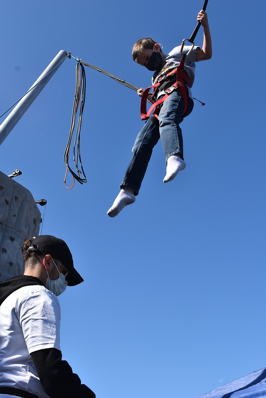 Employee Humberto Lleras launches Sarasota resident Colin Harden, 7, on the Power Jump. Harden said he had never been up so high, and he could almost see the top of the roof next door.