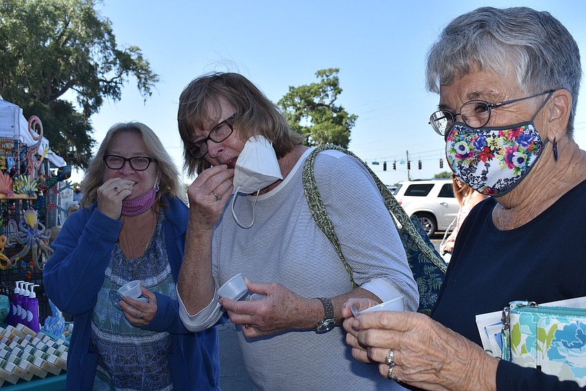 Zephyr Hills resident Carla Hodge and Bradenton residents JoAnn McCleery and Jan Frantz sample the baked goods at the booth run by Sarasota-based Ghost Coast. Hodge bought a rum cake to take home.