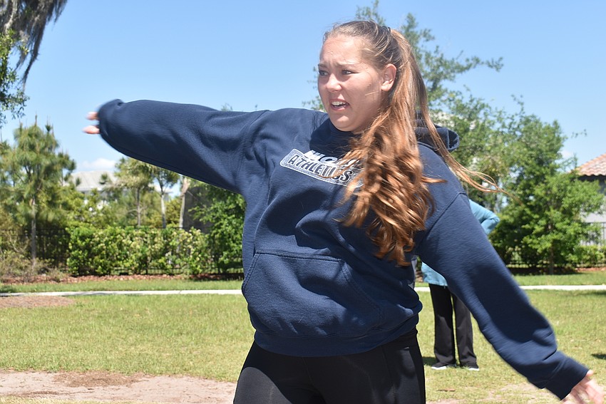 Indigo residents Anzhela Page launches her drive on the first hole. Page plays golf, which she said helped prepare her a little bit for the concept of disc golf and the angles of each hole.