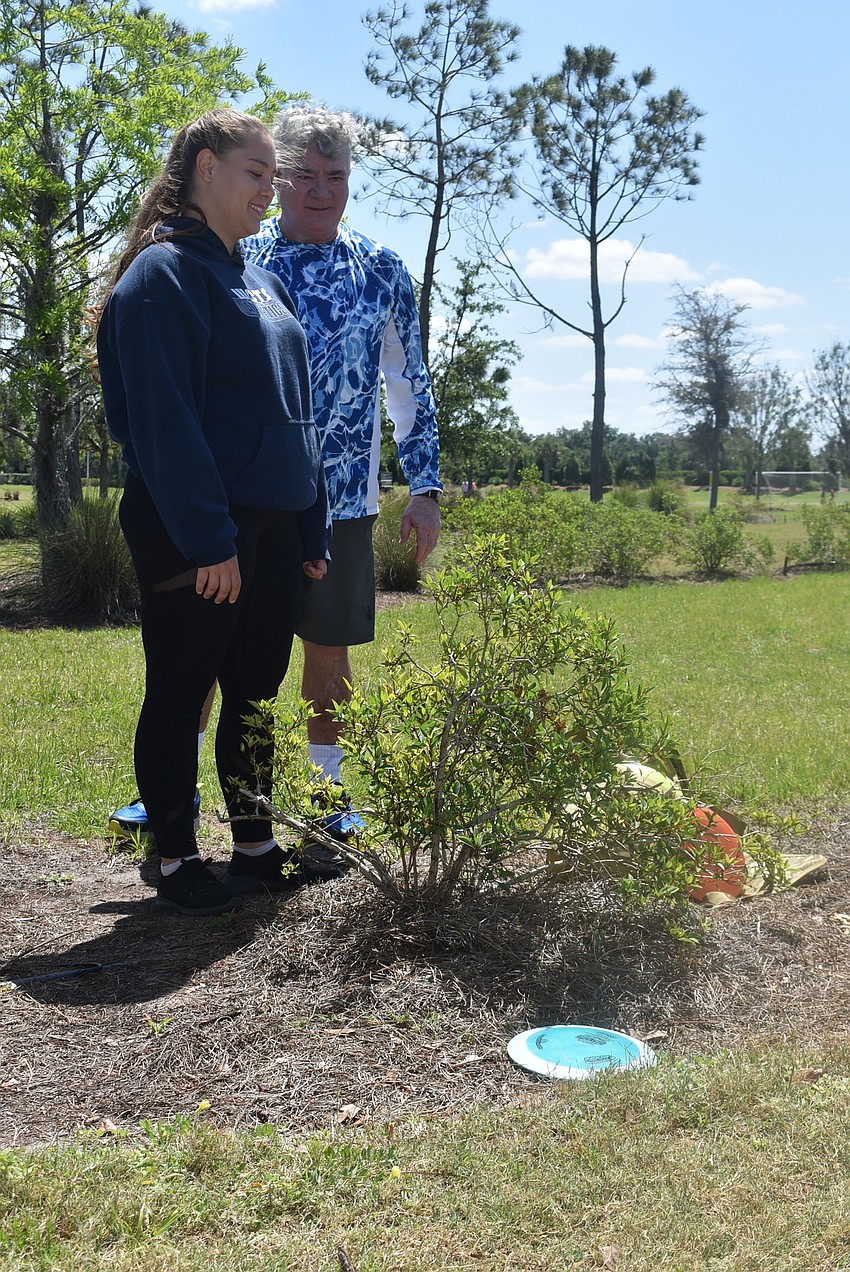 Indigo residents Anzhela Page and Mick Chianese study the position of a wayward drive on the first hole. Chianese played ultimate frisbee for 35 years and taught Page, his niece, to throw one when she was a child.
