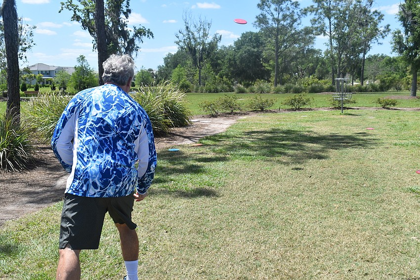 Indigo resident Mick Chianese launches and watches his approach shot land within a few feet of the basket. Chianese played ultimate frisbee for 35 years, but he had to adjust to the type of disc used in disc golf.
