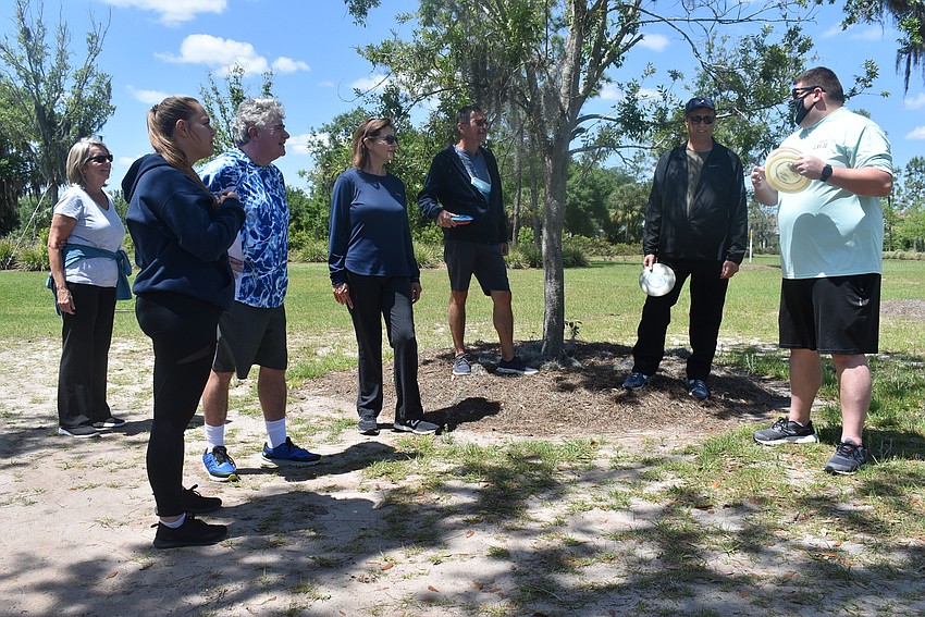 Lakewood Ranch Community Activity Parks Director Chris McComas (far right) explains to Disc Golf 101 attendees the concept of 