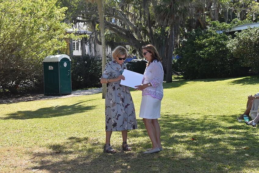 Cecile Coutret, right, accepts an award from Georgina Clamage for her and her husband's realty team.