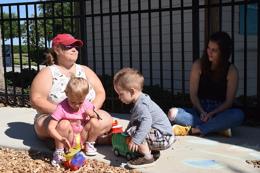 While Harmony's Jessi McComas talks with Harmony's Sandra Hall about sharing, their children Josie McComas and Jack Hall, play together.