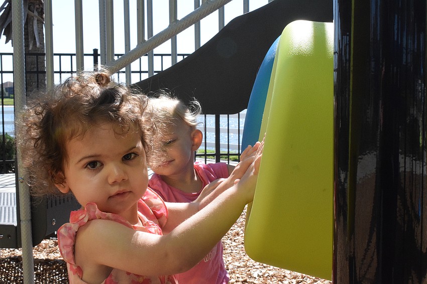Lakewood Ranch's Susanna Marconi Samuels, who is 2 years old, and Harmony's Josie McComas, who is 2 years old, make their own music using playground equipment.