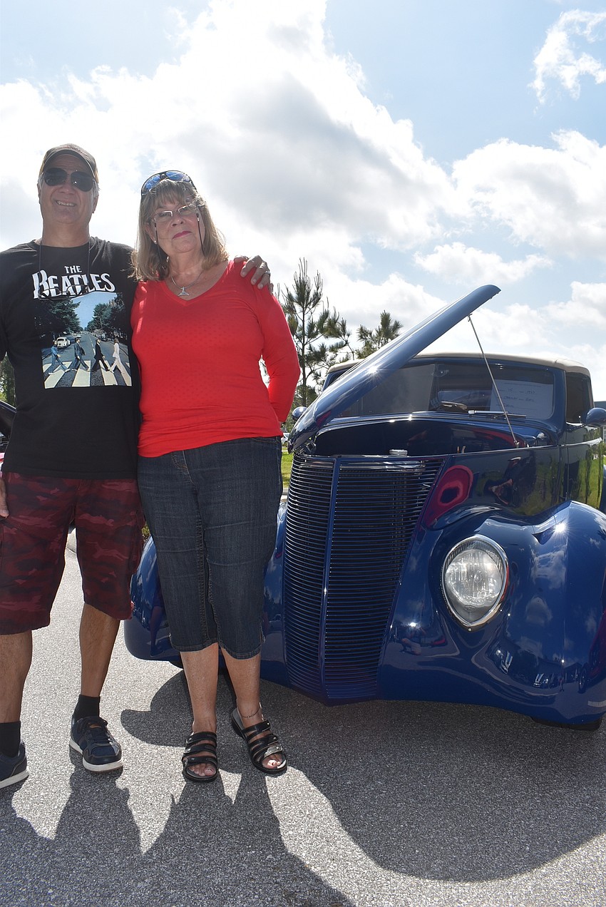 Gary Lebrun and Louise Laporte stand by a 1937 Ford Cabriolet owned by one of their friends. Lebrun cleaned the car the day before, which he said took him about five to six hours.